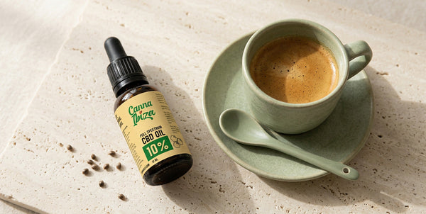 CBD dropper bottle next to a cup of espresso