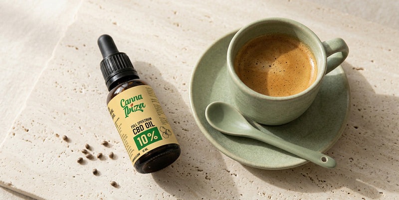 CBD dropper bottle next to a cup of espresso