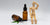 two brown dropper bottles and a wooden figure sitting next to it
