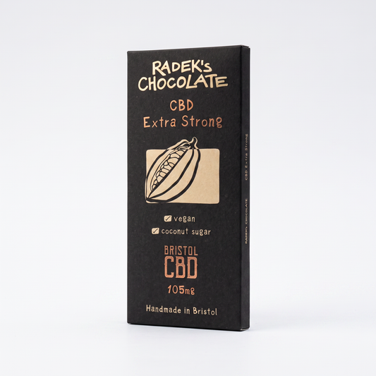 A single rectangular package of Radek's Chocolate CBD Extra Strong chocolate bar, standing upright on a clean white background. The packaging is matte black with gold and orange text and a small illustration of a cacao pod.