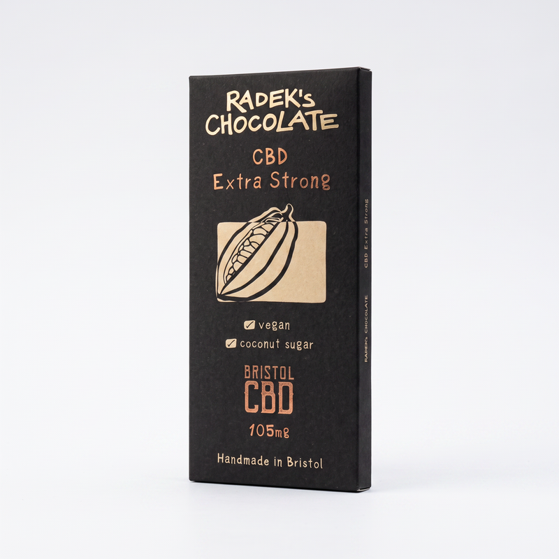 A single rectangular package of Radek's Chocolate CBD Extra Strong chocolate bar, standing upright on a clean white background. The packaging is matte black with gold and orange text and a small illustration of a cacao pod.